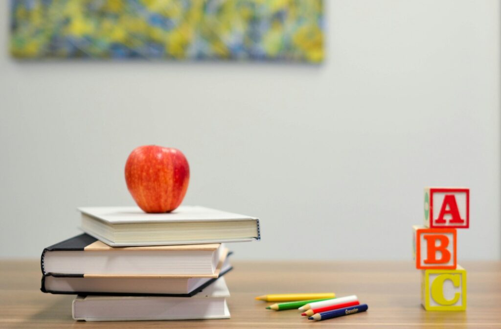 red apple fruit on four pyle books